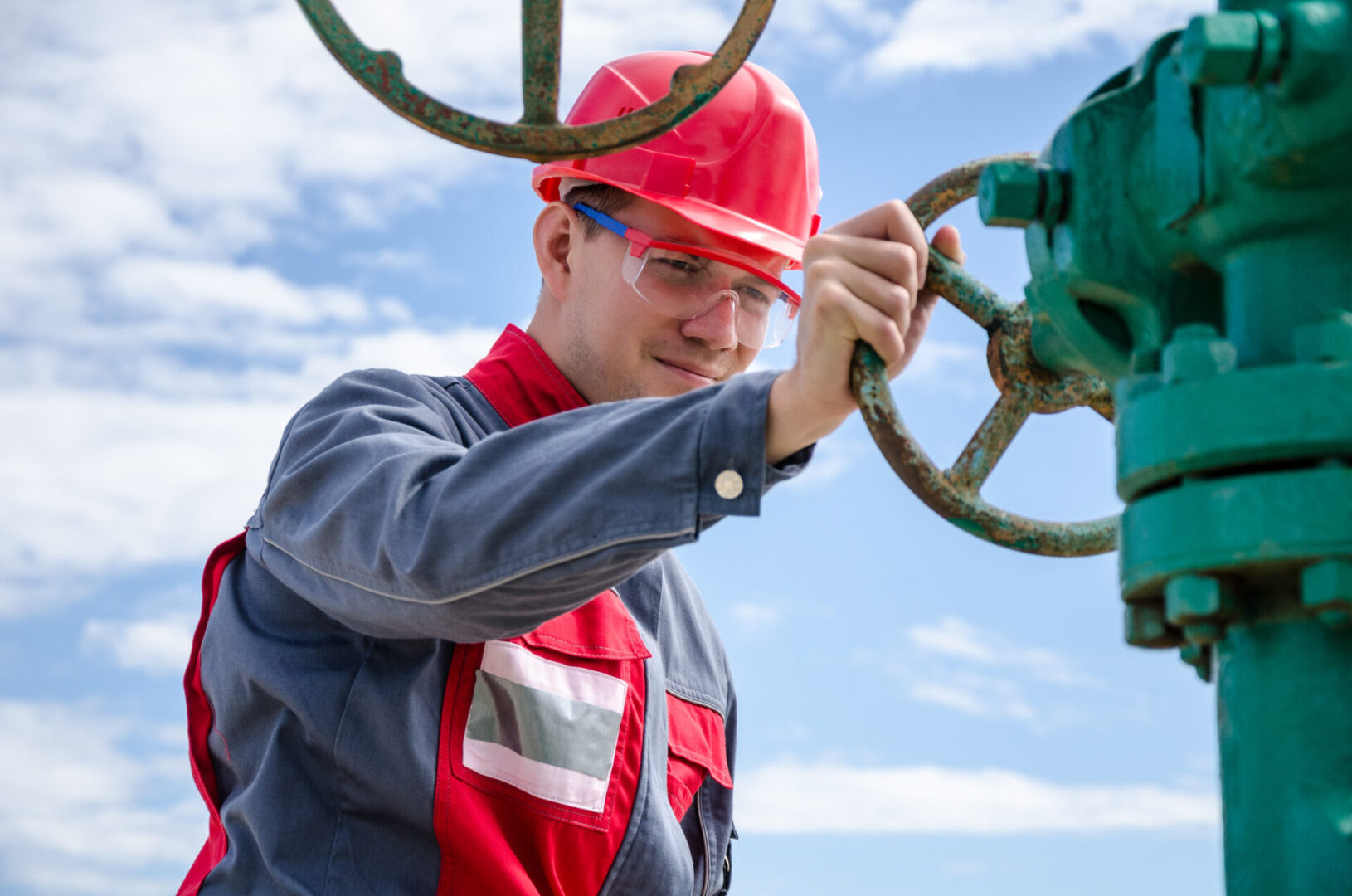 Worker,Near,Wellhead,Valve,Wearing,Red,Helmet,In,The,Oilfield.